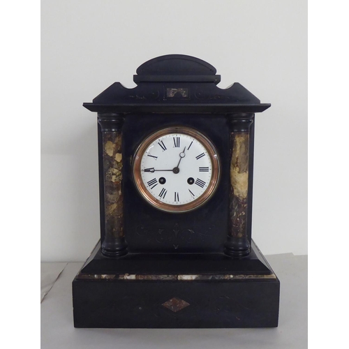 324 - A late Victorian black slate mantel clock of architectural form; the 8 day movement faced by a Roman... 