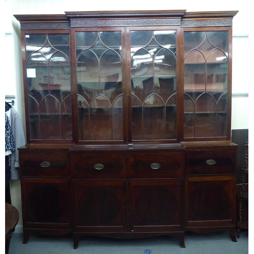 326 - A 19thC mahogany breakfront library bookcase with a blind fret carved cornice, over four ecclesiasti... 