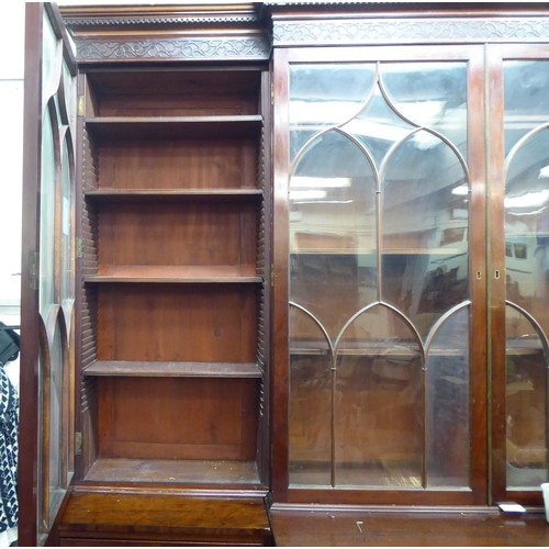 326 - A 19thC mahogany breakfront library bookcase with a blind fret carved cornice, over four ecclesiasti... 