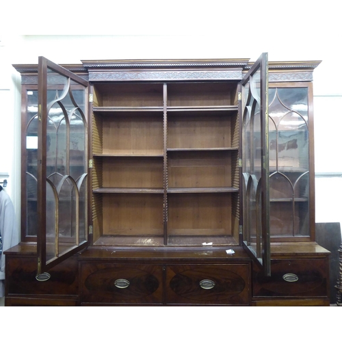 326 - A 19thC mahogany breakfront library bookcase with a blind fret carved cornice, over four ecclesiasti... 