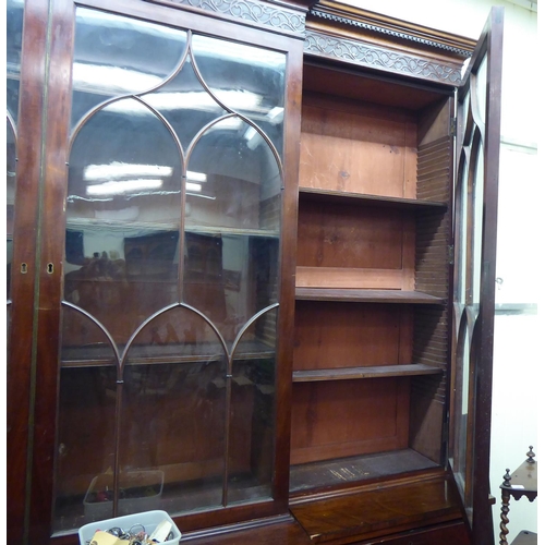 326 - A 19thC mahogany breakfront library bookcase with a blind fret carved cornice, over four ecclesiasti... 