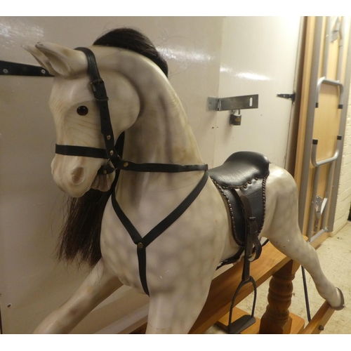 329 - A modern hardwood dapple grey painted rocking horse with a leatherette saddle, raised on a pillar ba... 