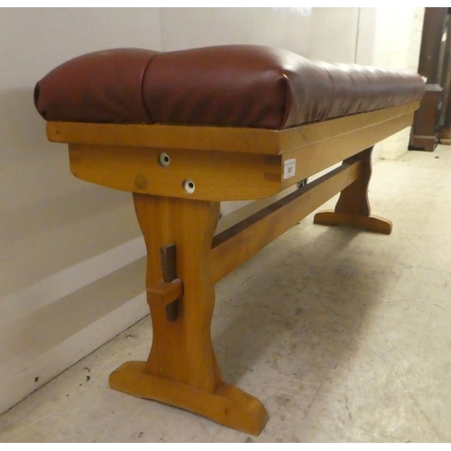 341 - A modern pine duet stool with a part-button upholstered, simulated red hide cushioned top