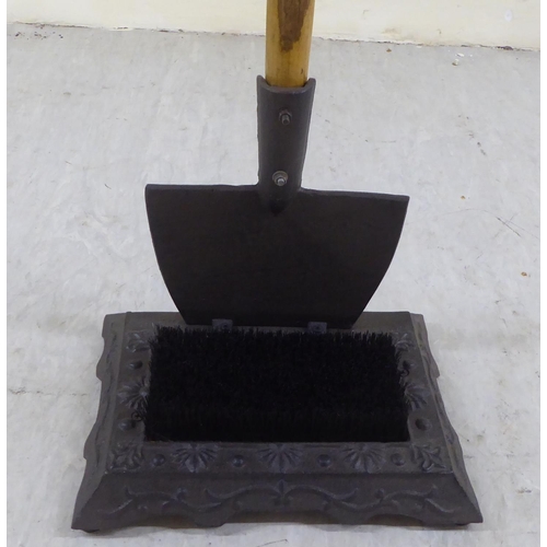 70 - A modern boot scraper, the cast iron brush base surmounted by a wooden handled spade  33