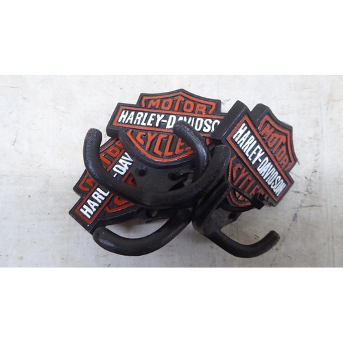 73 - A set of three cast iron, twin handled coat hooks, branded for 'Harley Davidson'  each 4