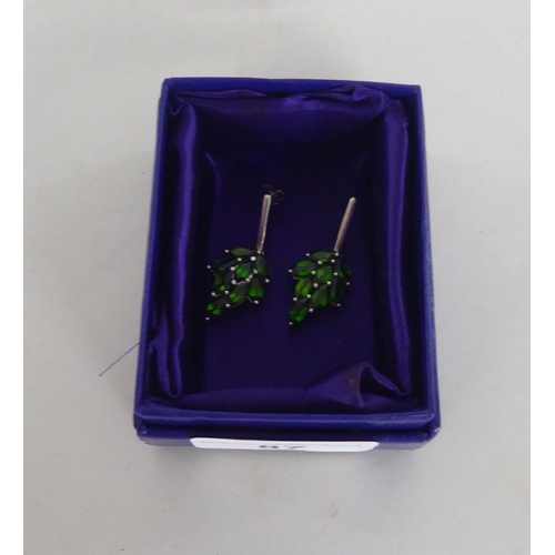 87 - A pair of white metal earrings, fashioned as leaves, set with green stones  stamped 925