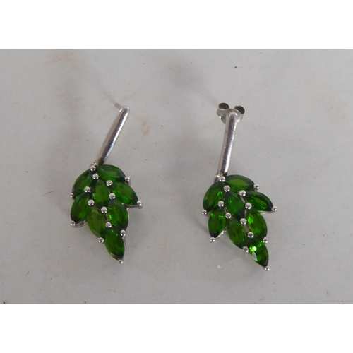 87 - A pair of white metal earrings, fashioned as leaves, set with green stones  stamped 925