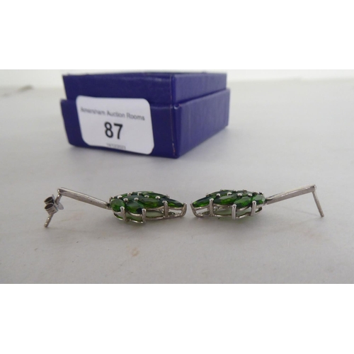 87 - A pair of white metal earrings, fashioned as leaves, set with green stones  stamped 925