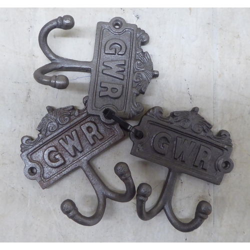 92 - A set of three cast iron, twin handled coat hooks, branded for 'GWR'  each 4