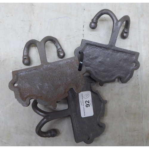 92 - A set of three cast iron, twin handled coat hooks, branded for 'GWR'  each 4