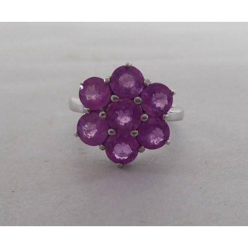 97 - A white metal cluster ring, set with seven pink sapphires  stamped 925