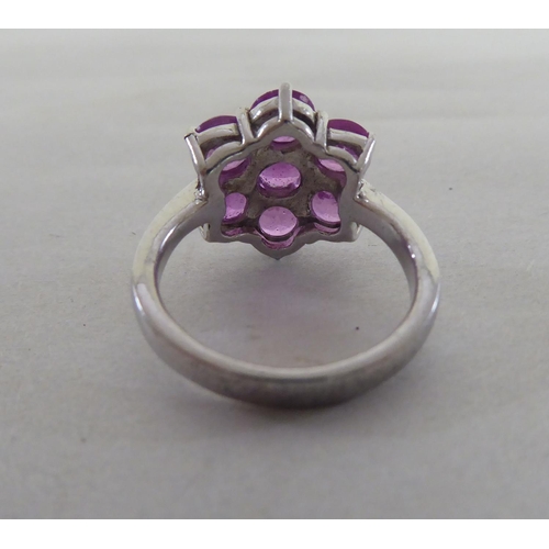 97 - A white metal cluster ring, set with seven pink sapphires  stamped 925