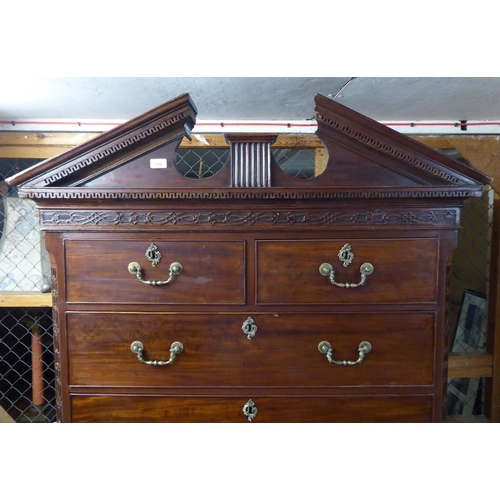 105 - A George III mahogany chest-on-chest with a broken arch cornice and Greek Key style dentil moulding,... 