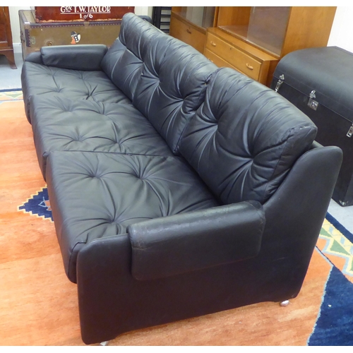 106 - A modern Pirelli moulded stitched black hide upholstered three person low back settee with enclosed ... 