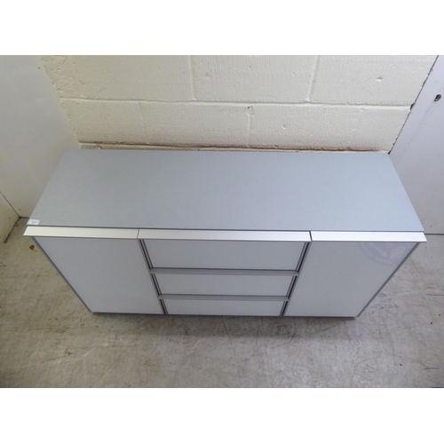 111 - A modern white and grey laminate and satin silver coloured metal mounted sideboard, comprising a ban... 