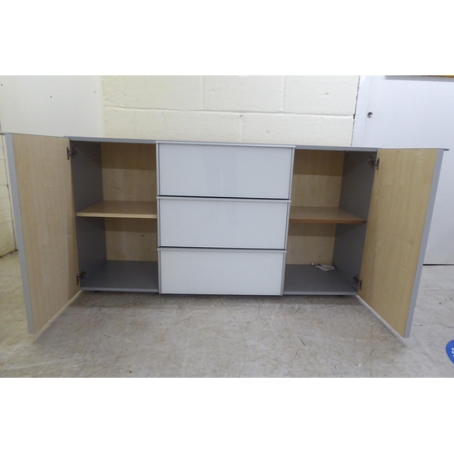 111 - A modern white and grey laminate and satin silver coloured metal mounted sideboard, comprising a ban... 