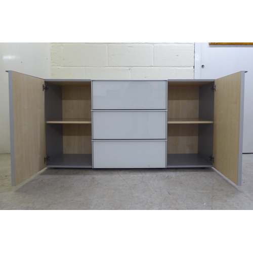 112 - A modern white and grey laminate and satin silver coloured metal mounted sideboard, comprising a ban... 