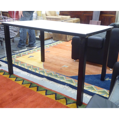 114 - A modern black enamelled steel work table with a white laminate top, raised on square legs  30