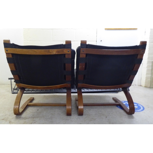 121 - A pair of modern stained and laminated sprung beech framed chairs with black canvas and buttoned hid... 