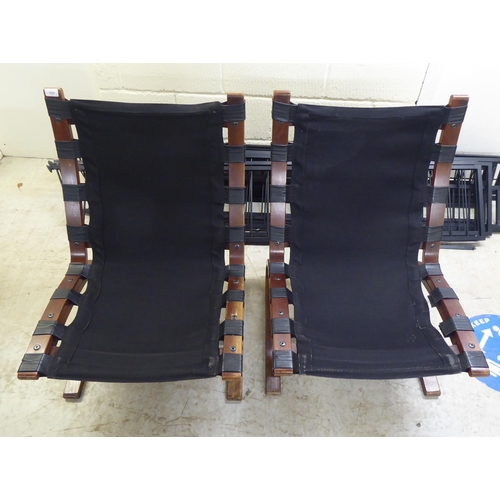 121 - A pair of modern stained and laminated sprung beech framed chairs with black canvas and buttoned hid... 