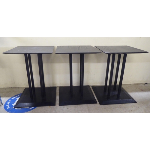 126 - A set of three modern black stained oak lamp tables, raised on a cluster of square section supports&... 