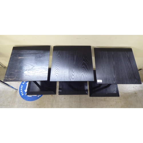 126 - A set of three modern black stained oak lamp tables, raised on a cluster of square section supports&... 