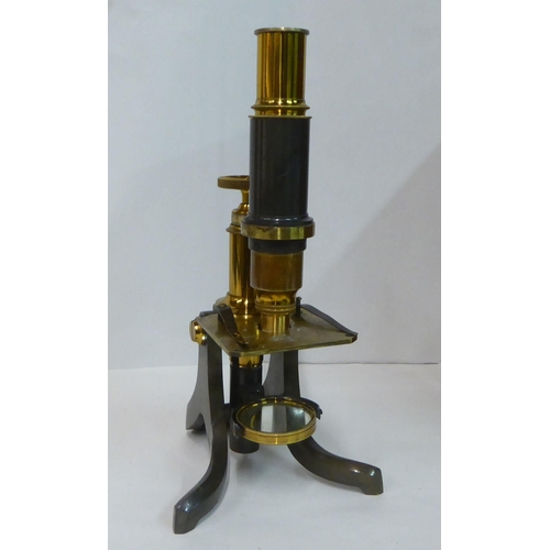 153 - An early 20thC brass microscope with a collection of slides, in a mahogany case