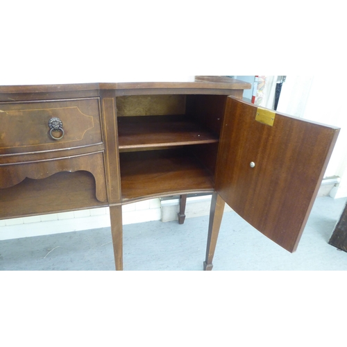 230 - A 20thC reproduction of a Georgian string inlaid mahogany breakfront bow sideboard, raised on square... 