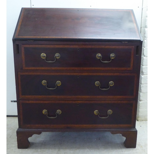 231 - An Edwardian crossbanded, ebony inlaid mahogany bureau, the fall flap over three drawers, raised on ... 