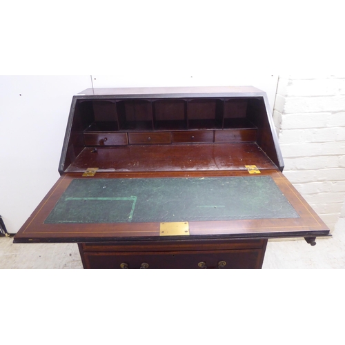 231 - An Edwardian crossbanded, ebony inlaid mahogany bureau, the fall flap over three drawers, raised on ... 