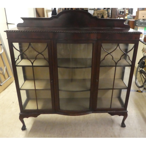 234 - A 1930s mahogany breakfront bow front display cabinet, raised on stubby cabriole legs, talon and bal... 