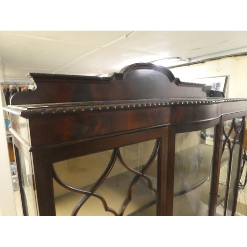 234 - A 1930s mahogany breakfront bow front display cabinet, raised on stubby cabriole legs, talon and bal... 