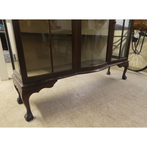 234 - A 1930s mahogany breakfront bow front display cabinet, raised on stubby cabriole legs, talon and bal... 