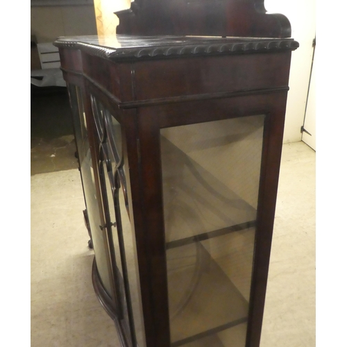 234 - A 1930s mahogany breakfront bow front display cabinet, raised on stubby cabriole legs, talon and bal... 