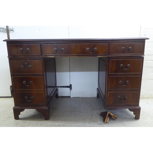 236 - A mid 20thC mahogany nine drawer, twin pedestal desk, raised on bracket feet  30