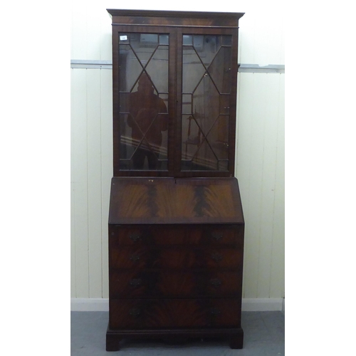 246 - A reproduction mahogany bureau bookcase, the upper section over a fall flap, over four graduated dra... 