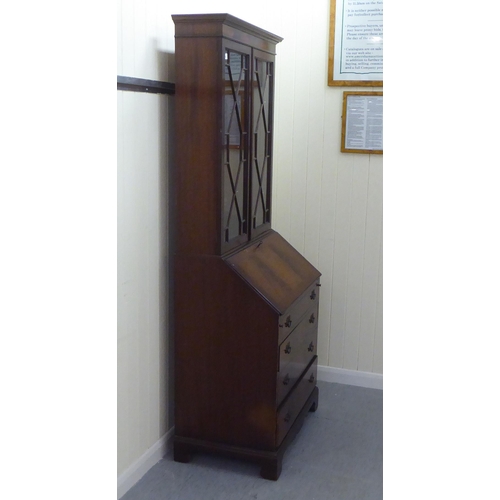 246 - A reproduction mahogany bureau bookcase, the upper section over a fall flap, over four graduated dra... 