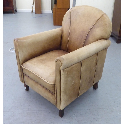 331 - An Art Deco inspired soft brown hide upholstered enclosed armchair, raised on tapered legs