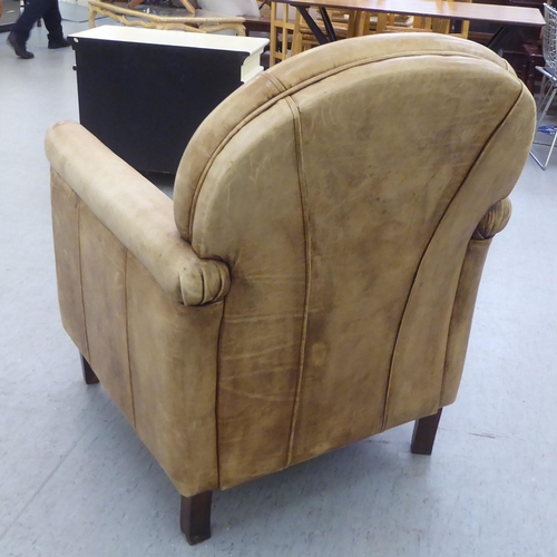 331 - An Art Deco inspired soft brown hide upholstered enclosed armchair, raised on tapered legs