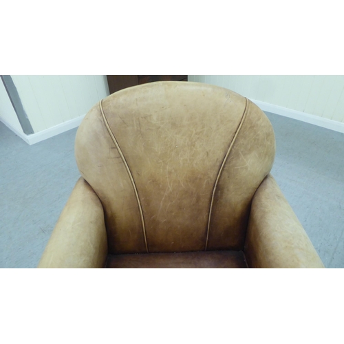 331 - An Art Deco inspired soft brown hide upholstered enclosed armchair, raised on tapered legs