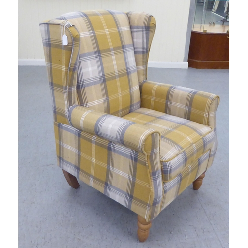 332 - A modern fabric upholstered, enclosed wingback armchair, raised on tapered forelegs