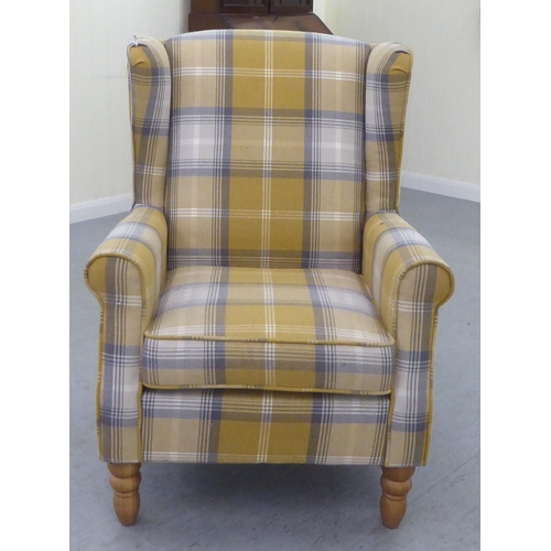 332 - A modern fabric upholstered, enclosed wingback armchair, raised on tapered forelegs