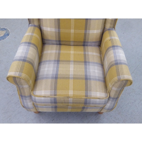 332 - A modern fabric upholstered, enclosed wingback armchair, raised on tapered forelegs