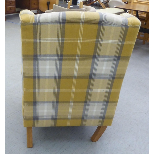 332 - A modern fabric upholstered, enclosed wingback armchair, raised on tapered forelegs