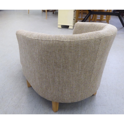 333 - A modern three tone textured, fabric upholstered tub chair and footstool, raised on tapered forelegs