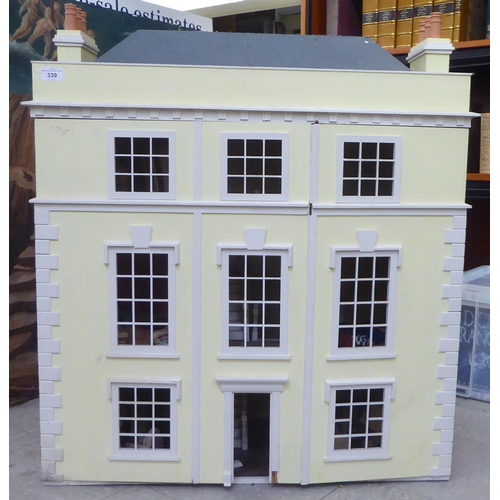 339 - A 20thC Georgian design, yellow and white painted, three storey doll's townhouse, the double opening... 