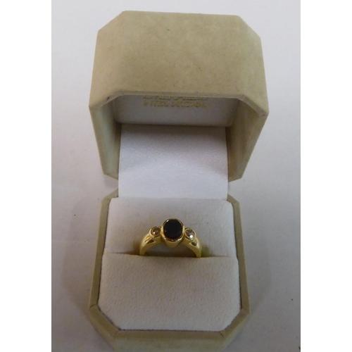 341 - A yellow metal ring, set with a blue stone, flanked by two diamonds