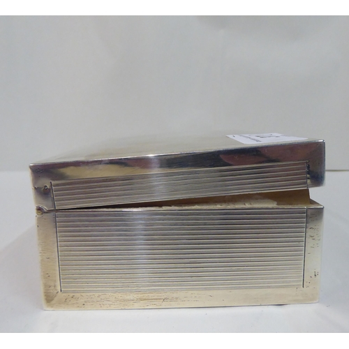 37 - A silver cigarette box with straight sides, a hinged lid and engine turned decoration  Birmingham 19... 