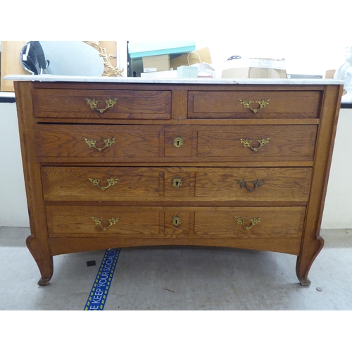 67 - A late 19thC Continental light oak, five drawer commode with a white marble top, raised on carved, t... 