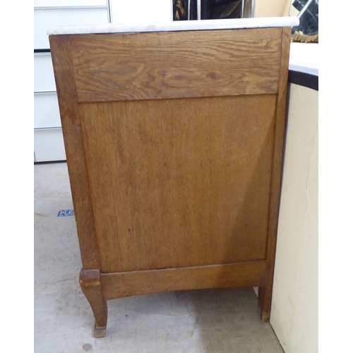 67 - A late 19thC Continental light oak, five drawer commode with a white marble top, raised on carved, t... 